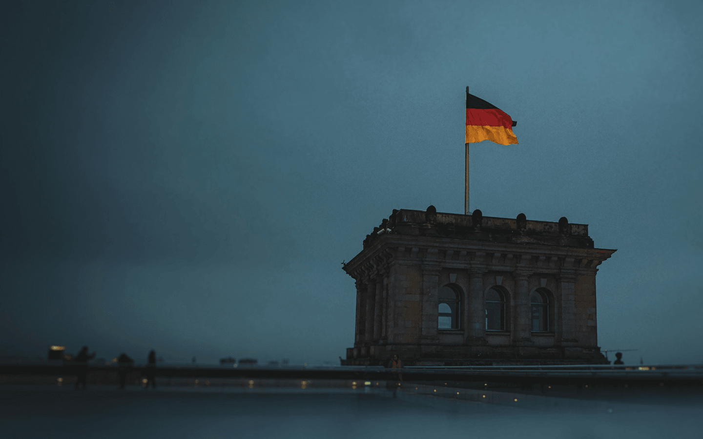 Cúpula do Reichstag com a bandeira da Alemanha ao entardecer